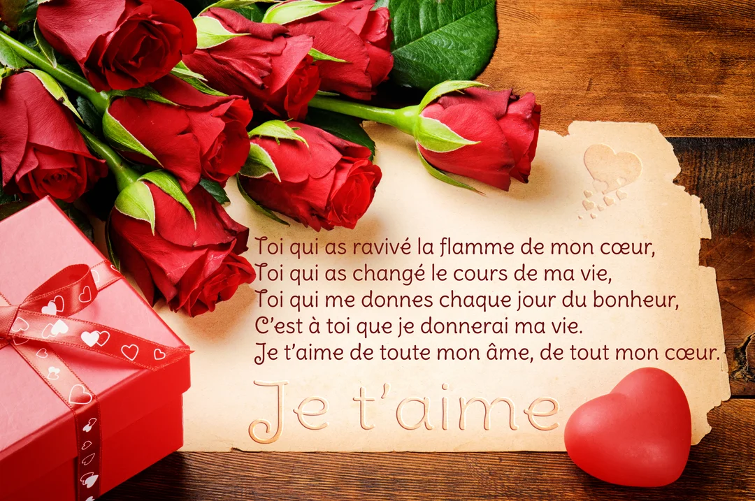 Une composition romantique avec un bouquet de roses rouges, un cadeau et une lettre d'amour poétique sur une table en bois.