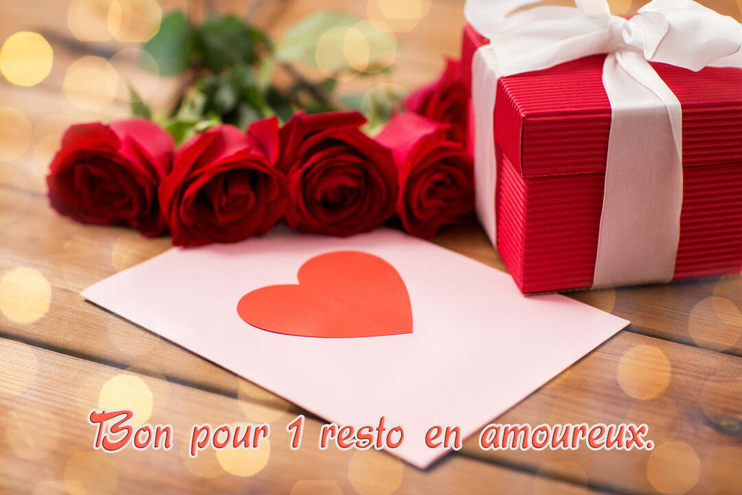 Une scène romantique avec des roses rouges, un cadeau, et une carte avec un cœur posée sur une table en bois illuminée.