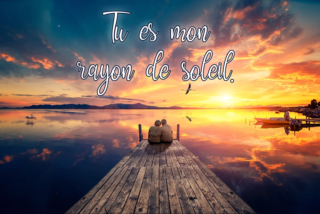 Un couple de dos est assis au bout d'un ponton en bois, contemplant un lac au coucher du soleil flamboyant sous un ciel nuageux.