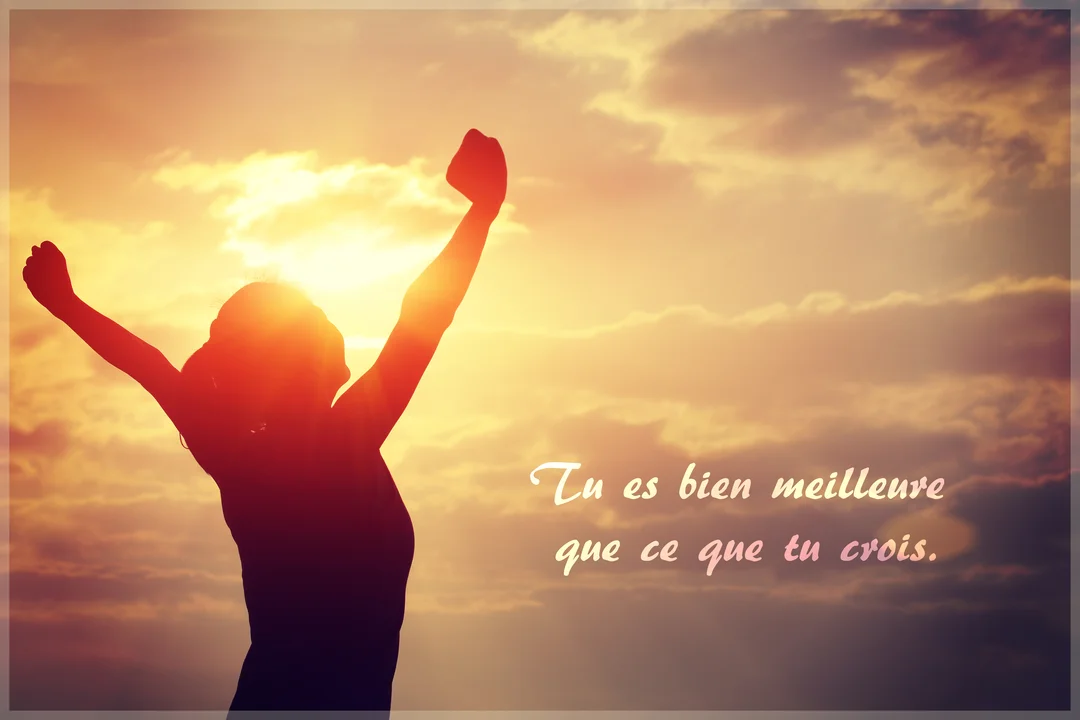 Silhouette d'une femme de dos, bras levés en signe de succès, se découpant sur un ciel nuageux au coucher du soleil.