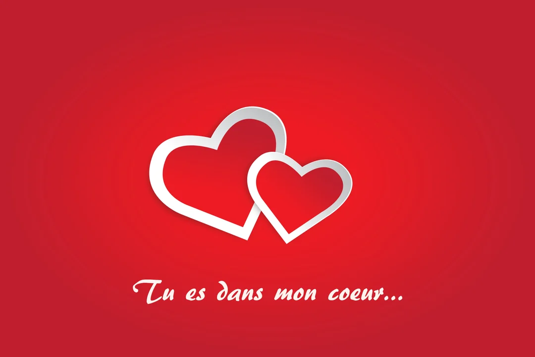 Sur un fond rouge uni, deux cœurs blancs stylisés avec un effet de relief se superposent au centre, juste au-dessus du texte 'Tu es dans mon cœur...'.