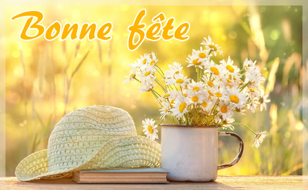 Une composition champêtre avec un bouquet de marguerites dans une tasse, un chapeau de paille et un livre posés sur une table en bois.