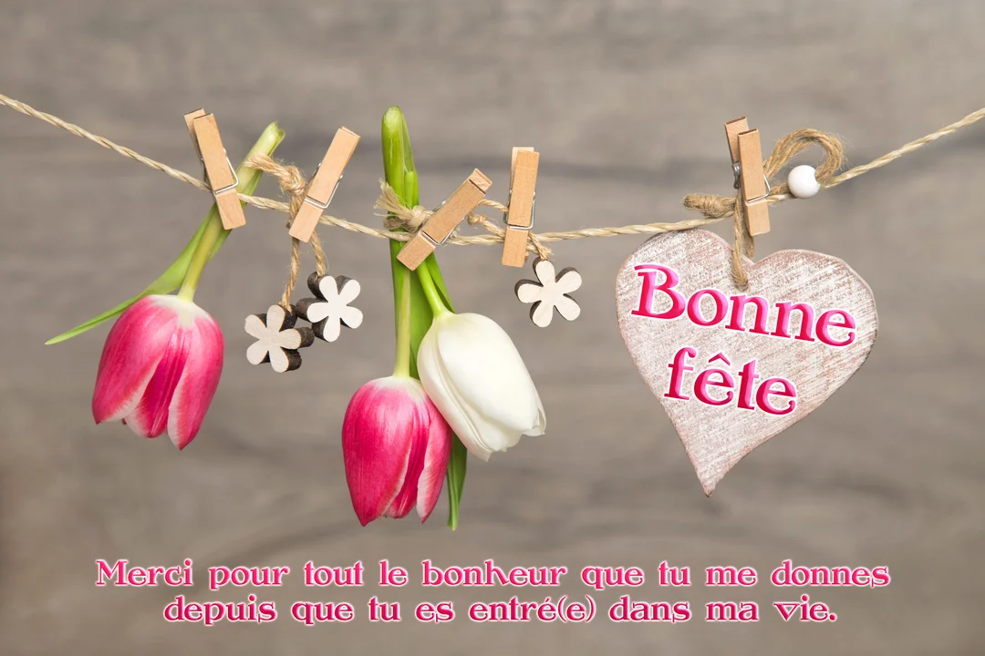 Sur un fond de bois, des tulipes et un cœur en bois sont accrochés à une cordelette à l'aide de petites pinces à linge.