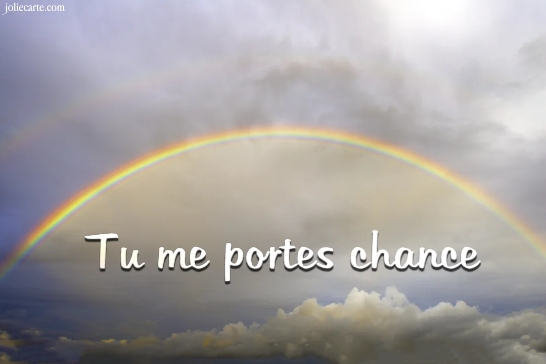 Un double arc-en-ciel aux couleurs vives se déploie dans un ciel rempli de nuages gris et blancs, avec le texte 'Tu me portes chance' au centre.
