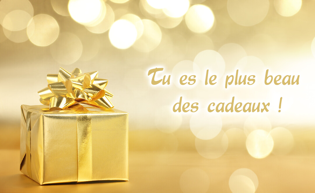 Un paquet cadeau cubique, enveloppé de papier doré brillant avec un nœud assorti, posé sur un fond de lumières dorées en bokeh.
