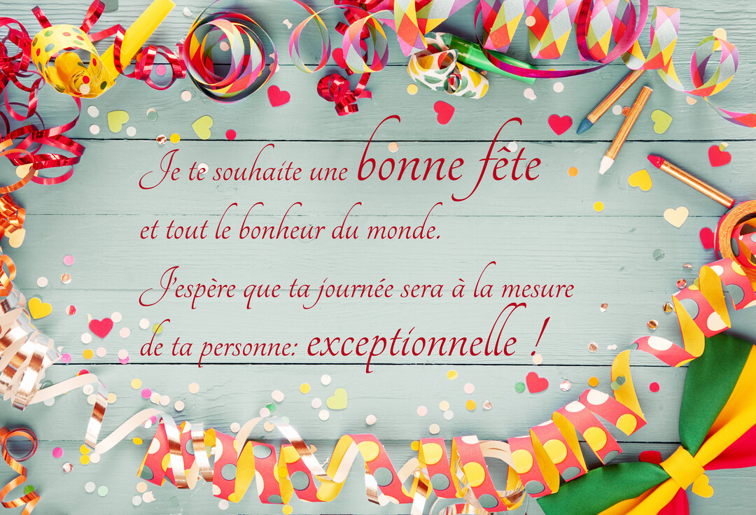 Une composition festive vue de dessus avec des serpentins et des confettis colorés encadrant un texte de vœux sur un fond en bois.