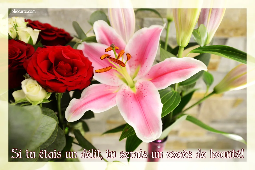 Un gros plan sur un bouquet luxuriant, mettant en vedette une fleur de lys rose épanouie, accompagnée de roses rouges et de feuillage vert.