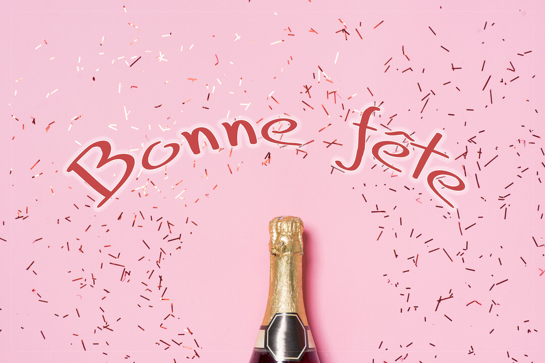 Vue de dessus d'une bouteille de champagne sur fond rose, avec le texte 'Bonne fête' et des confettis scintillants couleur or rose.
