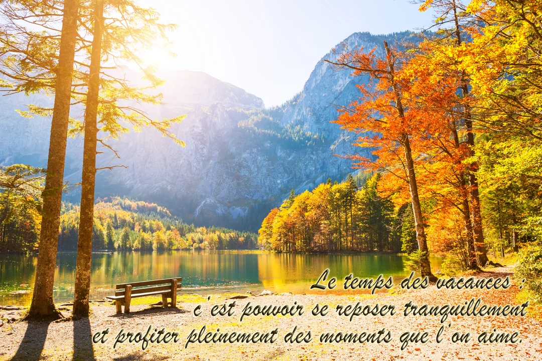 Un banc en bois fait face à un lac paisible, entouré d'une forêt aux couleurs automnales et de montagnes sous un soleil éclatant.