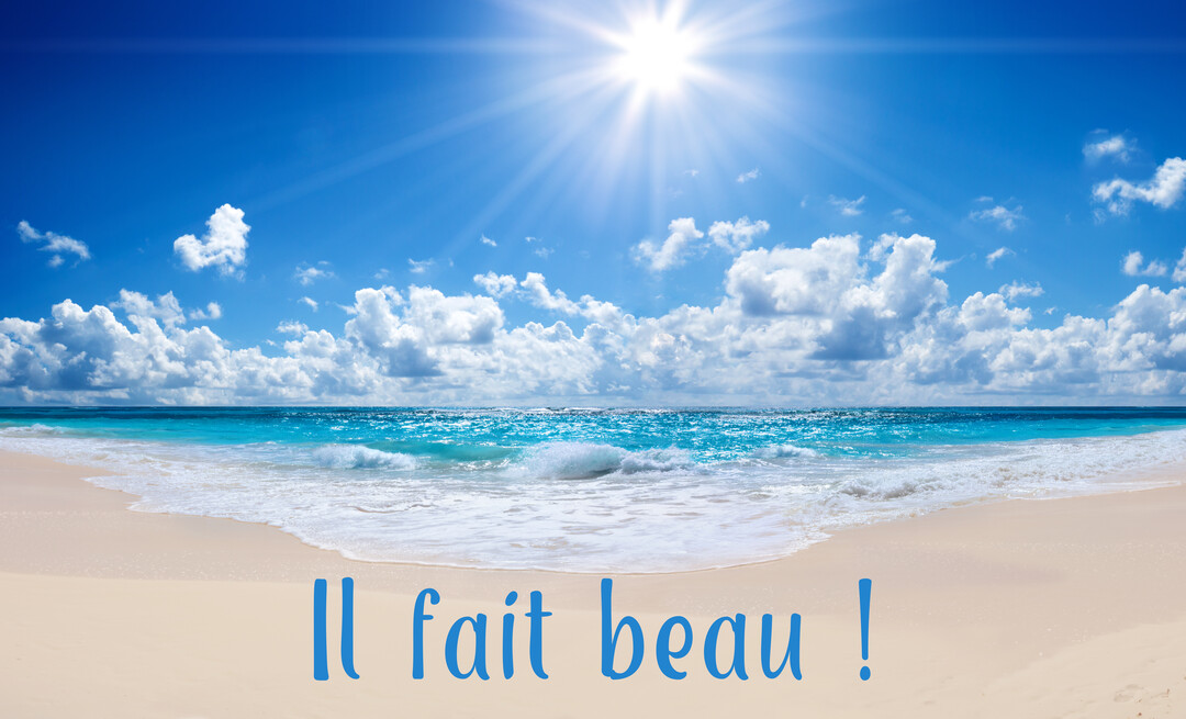 Paysage de plage tropicale avec une mer turquoise, du sable fin et un ciel bleu parsemé de nuages sous un soleil radieux.