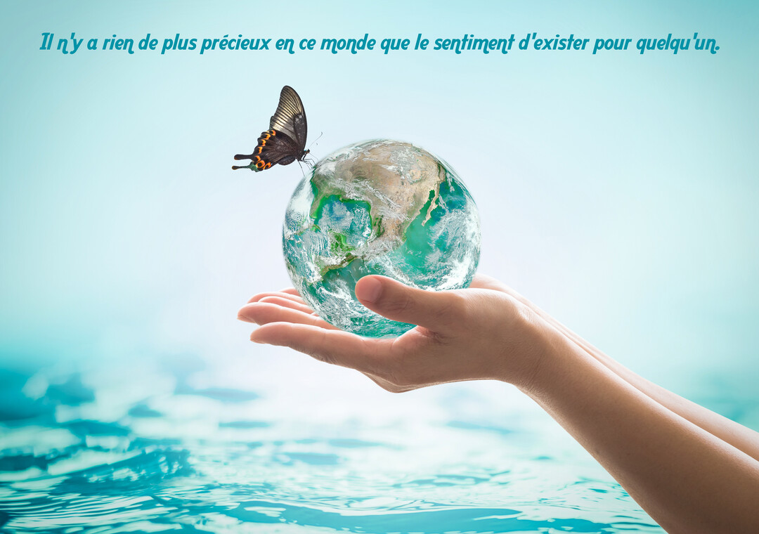 Des mains sortant de l'eau tiennent un globe terrestre sur lequel se pose un papillon, sous une citation inspirante.
