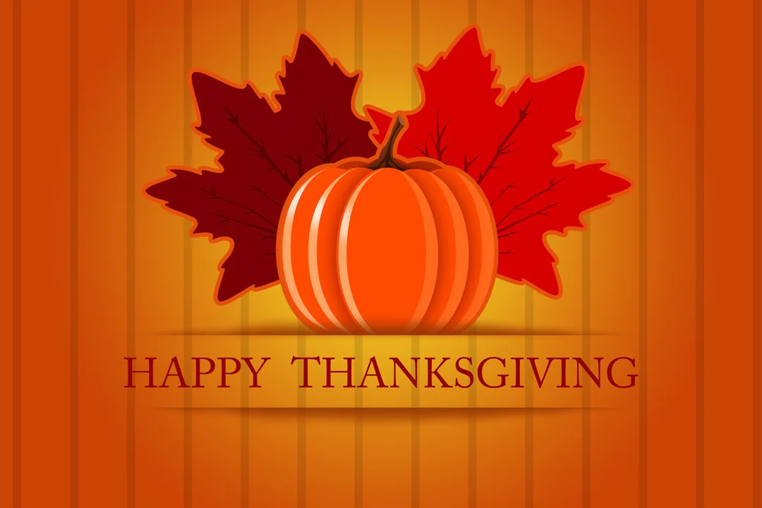 Une carte pour Thanksgiving montrant une citrouille orange devant deux feuilles d'érable rouges, sur un fond à rayures verticales orange et jaunes.