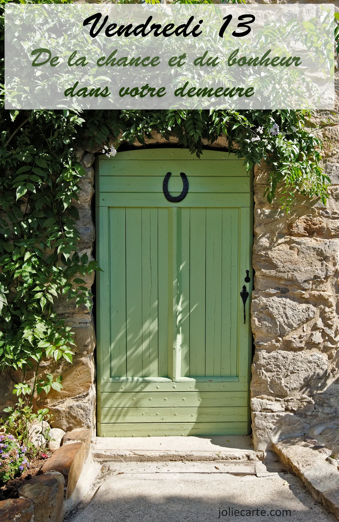 Une porte en bois vert clair, surmontée d'un fer à cheval noir, est encadrée par un mur en pierre et de la végétation luxuriante et ensoleillée.