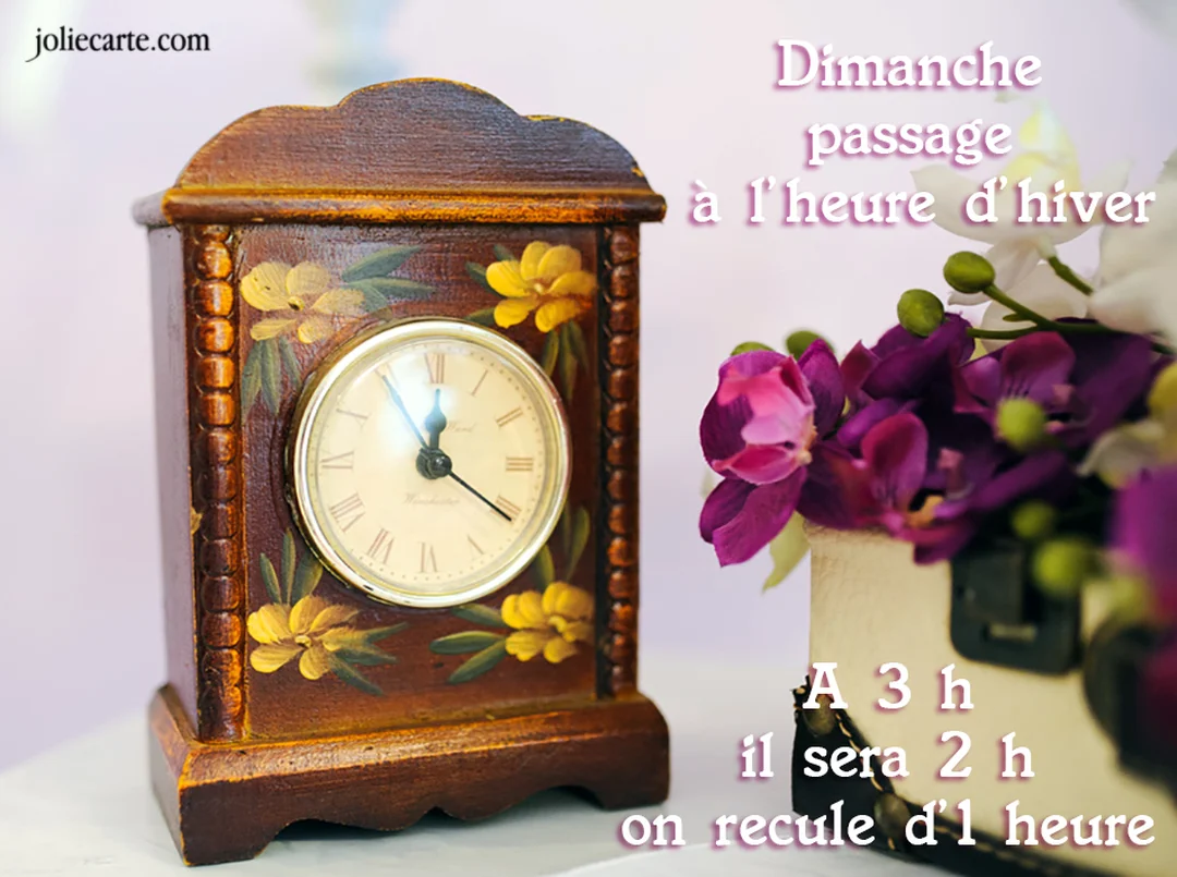 Une carte illustrée d'une horloge de cheminée en bois décorée de fleurs, avec un texte rappelant le passage à l'heure d'hiver.