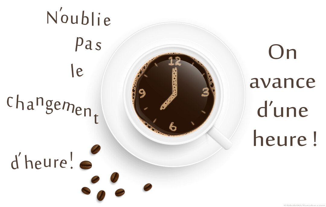 Vue de dessus d'une tasse de café sur fond blanc, où la mousse dessine une horloge indiquant le changement d'heure à venir.