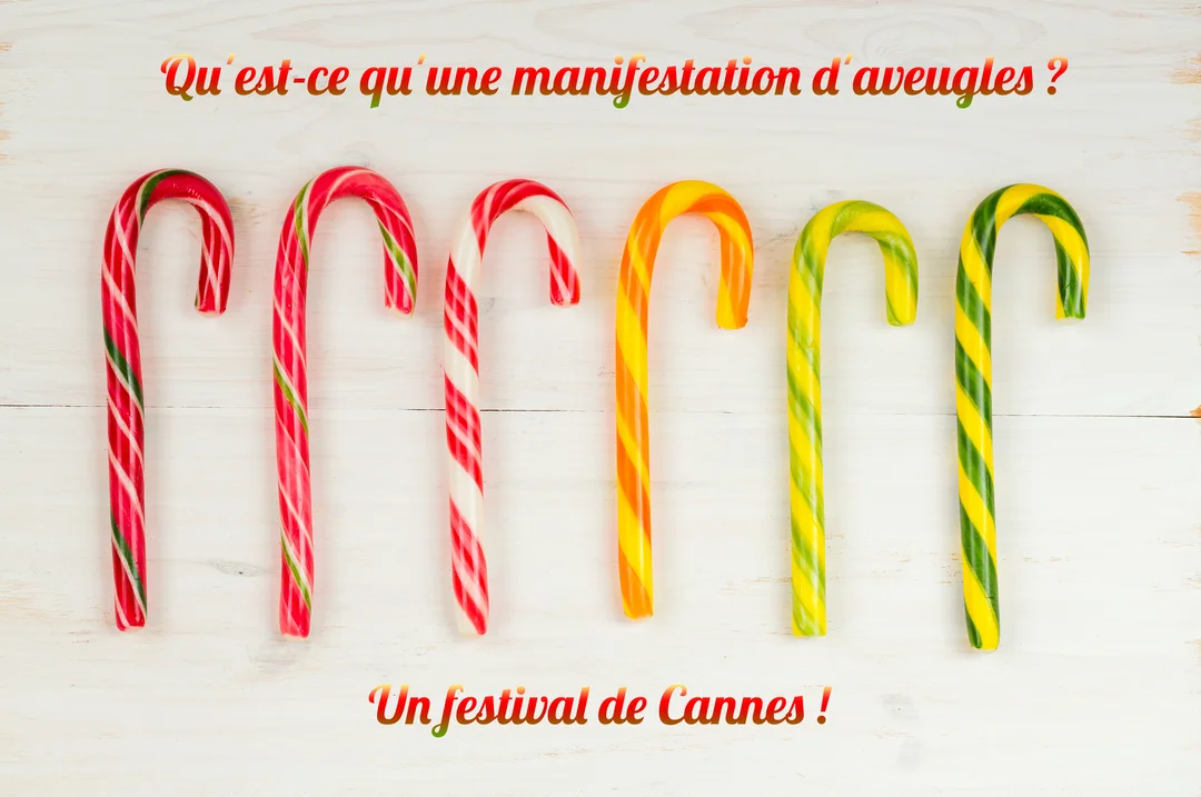 Six sucres d'orge colorés sont alignés horizontalement sur un fond en bois blanc, avec une blague écrite au-dessus et en-dessous.