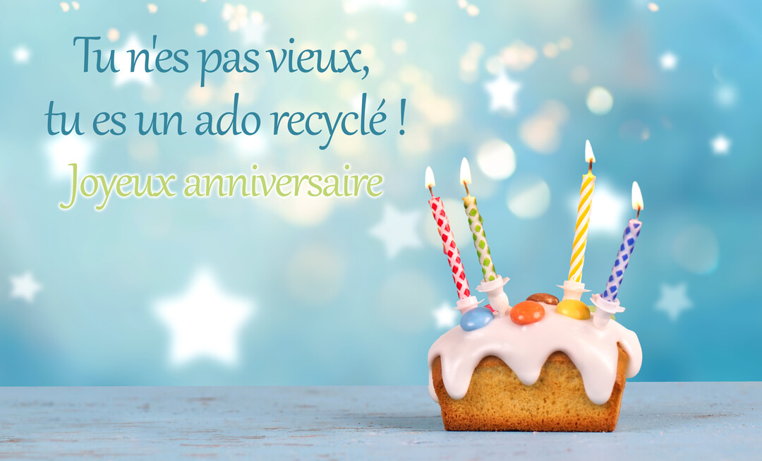 Un petit gâteau d'anniversaire avec des bougies allumées, posé sur une table bleue, avec un texte humoristique sur un fond étoilé.