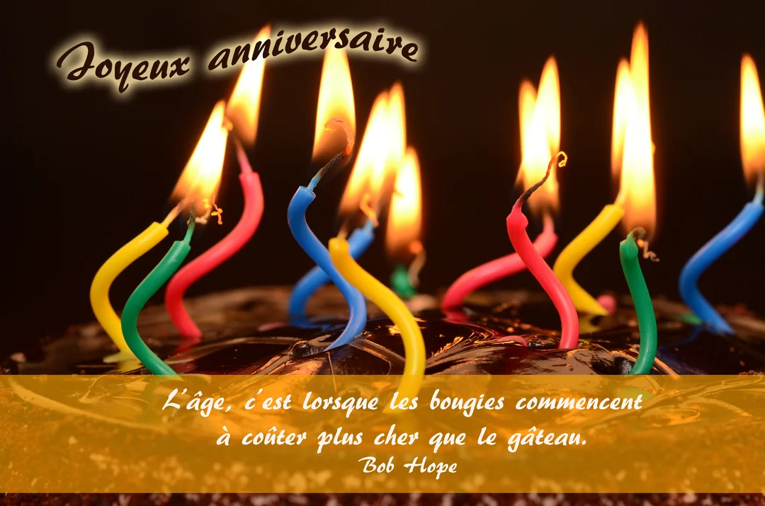 Un gros plan sur un gâteau au chocolat surmonté de nombreuses bougies colorées et torsadées, allumées sur un fond noir uni.