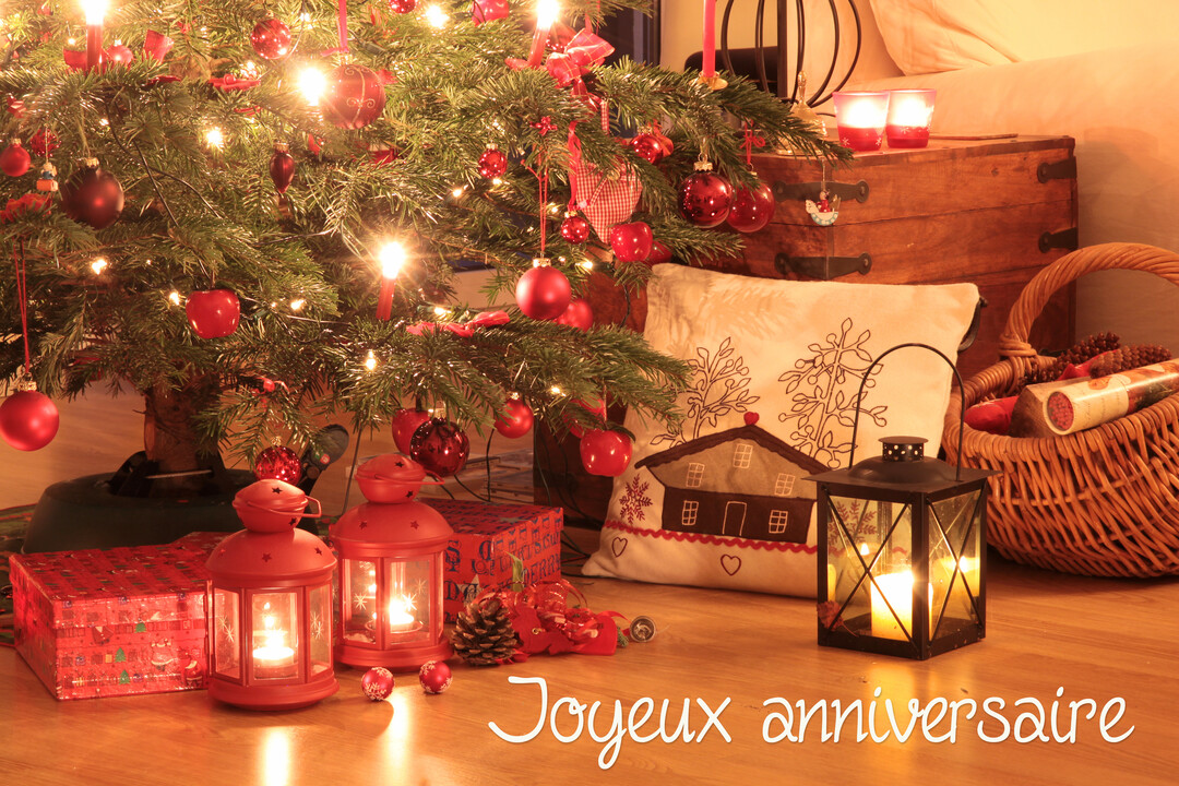 Au pied d'un sapin de Noël illuminé, des cadeaux et des lanternes sont posés sur un parquet, créant une scène festive et chaleureuse.