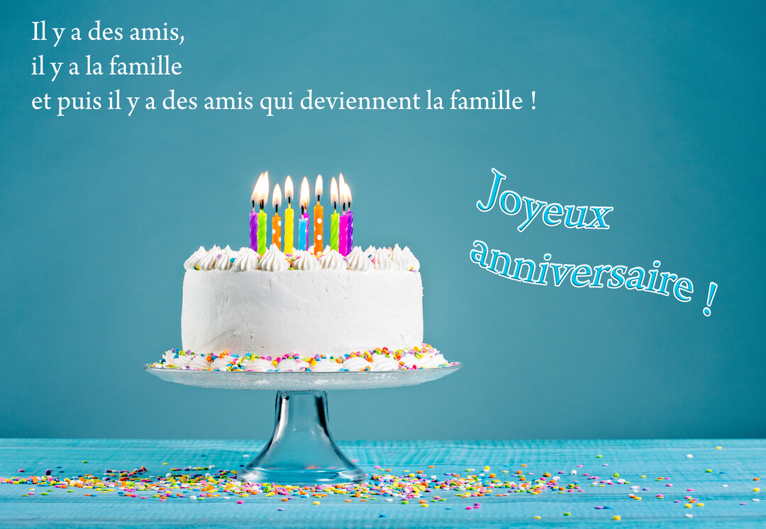 Un gâteau d'anniversaire blanc, surmonté de bougies multicolores allumées, repose sur un présentoir en verre, entouré de confettis sur fond bleu.