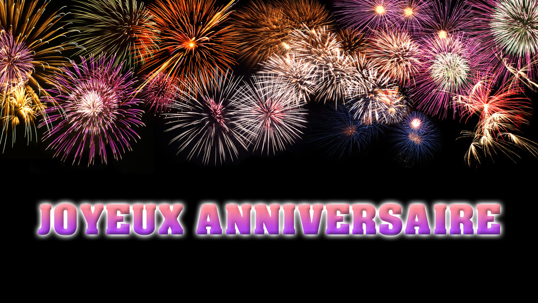 Plusieurs feux d'artifice colorés explosent dans un ciel nocturne, au-dessus du texte « Joyeux Anniversaire » en dégradé rose et violet.