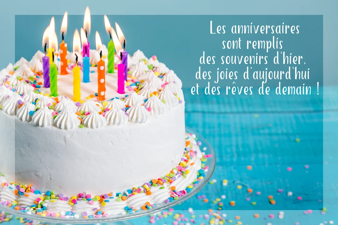 Un gâteau d'anniversaire blanc, couvert de vermicelles colorés et surmonté de bougies allumées, posé sur un fond bleu turquoise uni.