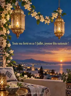 Deux lanternes dorées suspendues à des hauteurs différentes brillent sous un ciel bleu du soir, avec des guirlandes de jasmin blanc. Texte : « Toute ma fierté en ce 5 Juillet, joyeuse fête nationale ! »