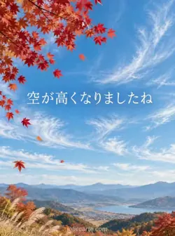 薄い雲の広がる高い青空を背景に、画面の隅から鮮やかな赤いカエデの枝が伸びている風景。