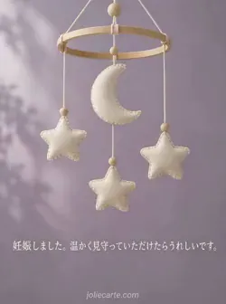 薄紫の背景に、木の輪から布の三日月と３つの星が下がるモビールを配した妊娠報告カード。
