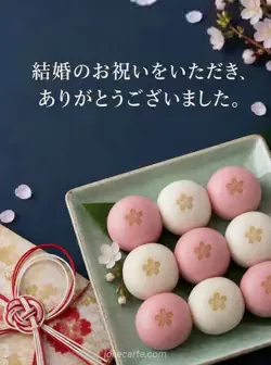 濃紺の背景に、青磁の長皿に並べた桃色と白のまんじゅうを配した結婚祝いのお礼カード。