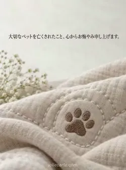 生成りのリネンに茶色の足跡と白い曲線の縫い目を施した、ペットへのお悔やみカード。