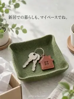 緑のフェルトのトレーに銀色の鍵と家形の革チャームを置いた、新居での暮らしを応援するカード。